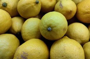 fechar acima pilha do limões dentro supermercado. saudável vegetariano fruta foto isolado em panorama modelo. uma grupo do azedo frutas.