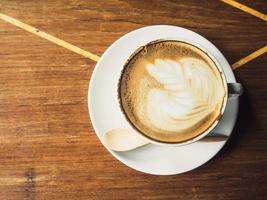 xícara de café com leite na madeira foto