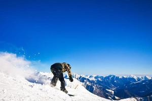 dinâmico cenário snowboarder em a pista dentro Cáucaso montanhas às velozes Rapidez ir descida foto