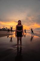 retrato do a ásia mulher dentro Preto roupas em pé em a de praia com uma muito triste expressão foto