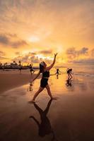 uma grupo do ásia mulheres dançando juntos e cheio do alegria em a de praia foto