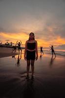 retrato do a ásia mulher dentro Preto roupas em pé em a de praia com uma muito triste expressão foto