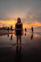 retrato do a ásia mulher dentro Preto roupas em pé em a de praia com uma muito triste expressão foto