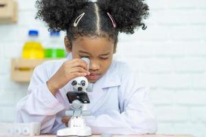 adorável pequeno menina cientista apreciar e excitar para examinar a cor químico dentro laboratório de usando conta-gotas com dia claro. animado criança a comemorar sobre bem sucedido Ciência experimentar resultado ou químico foto