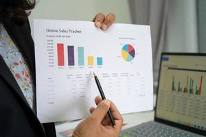 contador asiático trabalhando e analisando contabilidade de projeto de relatórios financeiros com gráfico gráfico e calculadora no conceito moderno de escritório, finanças e negócios. foto