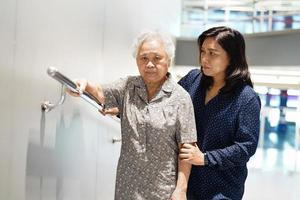 ásia Senior ou idosos velho senhora mulher paciente usar declive passarela lidar com segurança com Socorro Apoio, suporte assistente dentro enfermagem hospital ala, saudável Forte médico conceito. foto