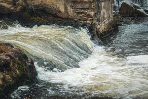 cascata corrente com espuma debaixo a ponte dentro belmontas parque dentro vilnius foto