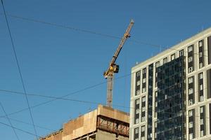 construção guindaste em a fundo do a prédio. construção do uma Novo apartamento construção foto