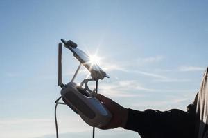 jovem navegando em um drone voador com controle remoto foto