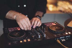 um dj toca música em um controlador em uma festa. foto