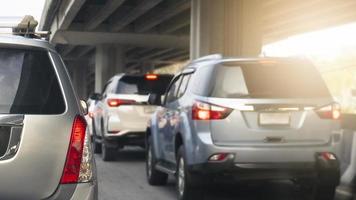 traseiro lado do prata família carro em a estrada com virar em freio claro. debaixo a concreto ponte. com de outros carros dentro a tráfego geléias durante pressa hora. foto