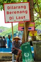 Yogyakarta, Indonésia dentro novembro 2022. foto do uma avô ou velho homem alugando tapetes às barão de praia.