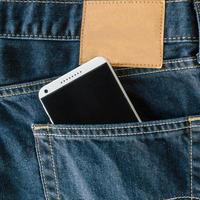 azul jeans jeans bolso com Móvel telefone. foto