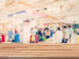 esvaziar madeira mesa e borrado fundo exibição às compras Shopping com espaço para produtos. foto