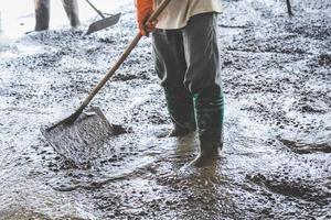 homem trabalhadores espalhando recentemente derramado concreto misturar em construção foto