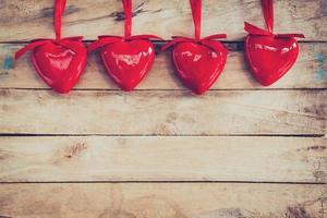 decorativo vermelho corações suspensão em vintage de madeira com espaço. namorados fundo. foto