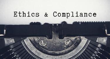 ética e conformidade texto digitado em a velho vintage máquina de escrever. conformidade conceito. foto