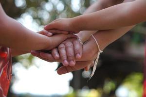 a mãos do uma criança e uma mãe Junte-se forças. foto