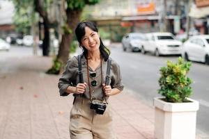 jovem ásia mulher mochila viajante desfrutando rua cultural local Lugar, colocar e sorriso. foto