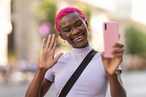 africano jovem mulher acenando às a Móvel ao ar livre foto