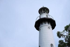 branco farol dentro a nublado dia fundo. foto