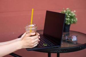 computador portátil com uma copo do café em a terraço foto