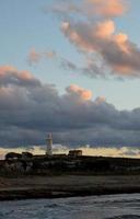 farol às pôr do sol em nublado céu background. patético, Chipre foto