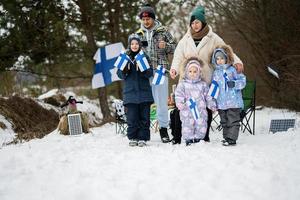 finlandês família com Finlândia bandeiras em uma agradável inverno dia. nórdico escandinavo pessoas. foto