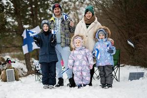 finlandês família com Finlândia bandeiras em uma agradável inverno dia. nórdico escandinavo pessoas. foto