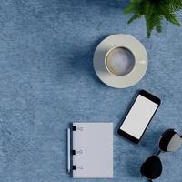 mock up notebook e smart phone na mesa azul foto