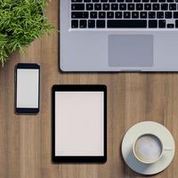 simulação de espaço de trabalho com telefone em branco e tablet na mesa foto