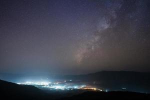 luzes da cidade e céu estrelado foto