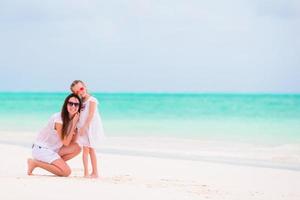 mãe e filha tendo Diversão em a de praia foto