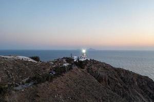 aéreo Visão do a acrotiri farol às pôr do sol dentro santorini, Grécia. foto