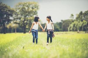 duas meninas de mãos dadas no parque foto