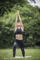 mulher fazendo ioga no parque foto