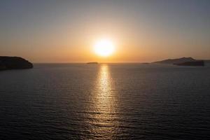 aéreo Visão do a costa do santorini, Grécia a partir de acrotiri às pôr do sol. foto