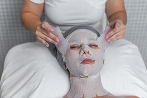 mulher recebendo gua sha facial massagem tratamento de esteticista dentro saúde spa foto