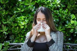 mulher com pólen alergia espirros com fechadas olhos foto