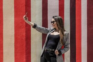 à moda mulher levando selfie dentro cidade em ensolarado dia foto