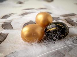 brilhante Páscoa. dourado Páscoa ovos em suave fofo penas foto