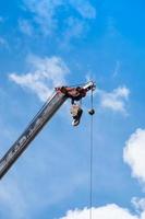 Móvel guindaste estrondo com gancho suspensão de fio cabo fundo azul céu, fechar acima foto