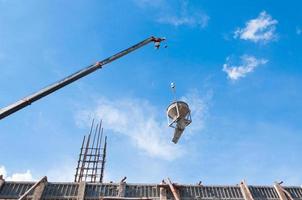 cimento ou concreto balde suspensão em fio às construção local com azul céu fundo foto