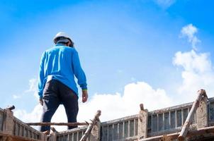 construção construção trabalhadores às construção, homem trabalhando às altura com azul céu às construção local foto
