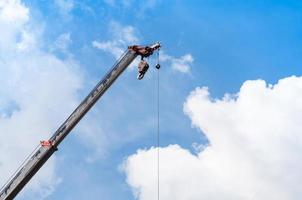 Móvel guindaste estrondo com gancho suspensão de fio cabo fundo azul céu, fechar acima foto