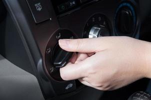 mulher mão girando em carro ar condicionamento sistema foto