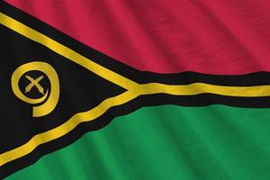 bandeira de vanuatu com grandes dobras acenando de perto sob a luz do estúdio dentro de casa. os símbolos oficiais e cores no banner foto