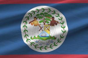 bandeira de belize com grandes dobras acenando perto sob a luz do estúdio dentro de casa. os símbolos e cores oficiais no banner foto