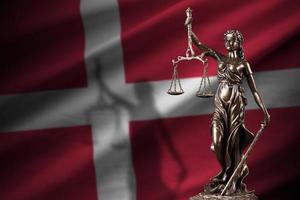 Dinamarca bandeira com estátua do senhora justiça e judicial balanças dentro Sombrio sala. conceito do julgamento e punição foto