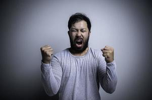 ásia bonito homem Bravo em branco plano de fundo, retrato do jovem estresse masculino conceito foto